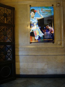 New Town Theatre 是贵州民族歌舞团的演出场地，在门口的大厅墙上挂着节目海报。